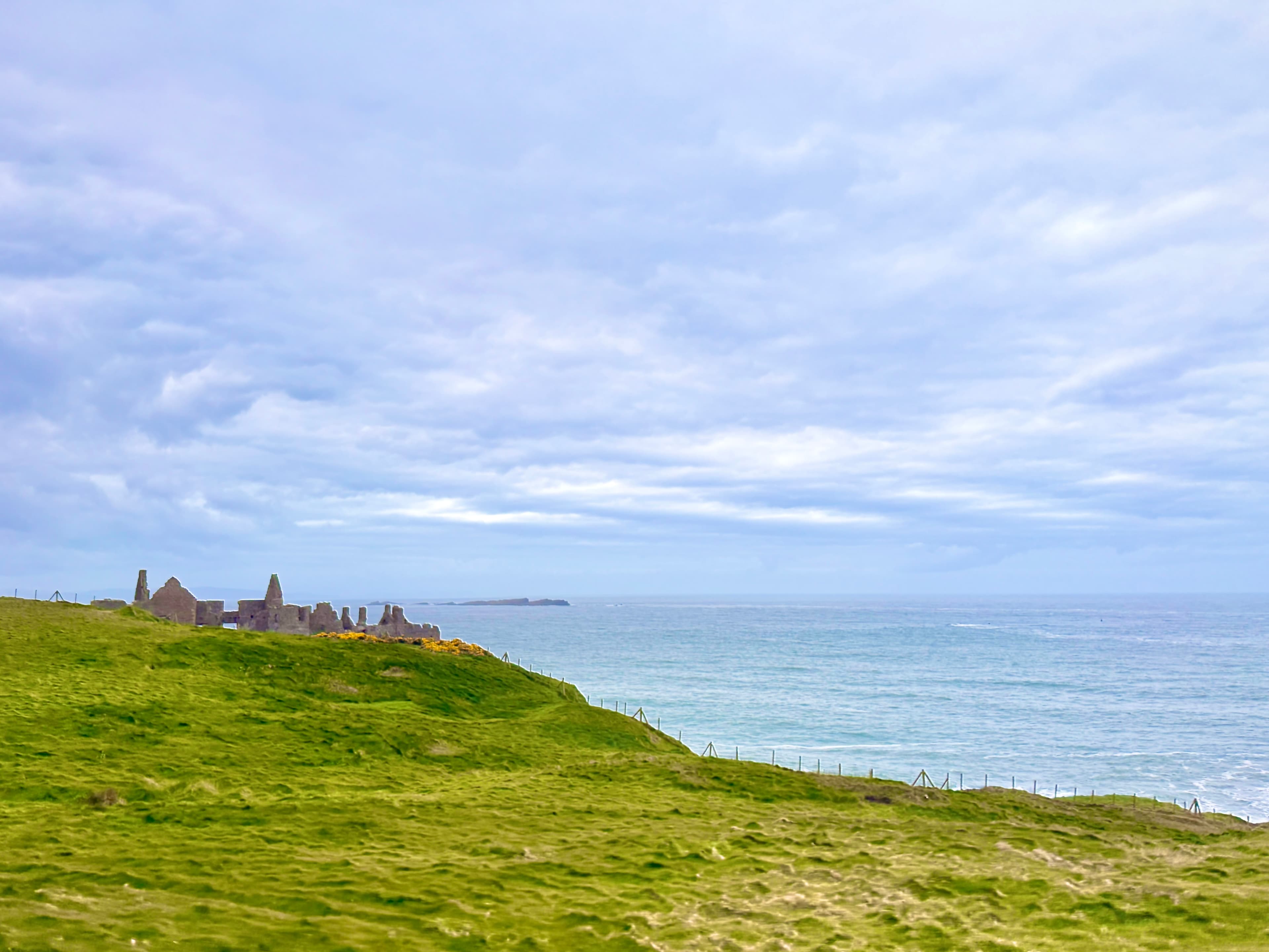 Coastal cliffs with stone ruins overlooking a calm sea
